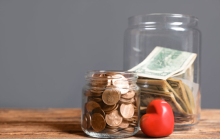 Two jars filled with coins and bills