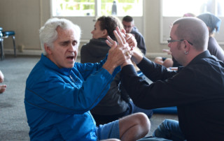 DeafBlind Retreat participant Steven Frank (left) in a yoga workshop during the 2009 DeafBlind Retreat at Seabeck, WA