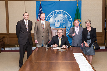 Washington State Governor Jay Inslee (center) signing House Bill No. 2398 with Representatives Jeff Holy and Marcus Riccelli (left), and Lighthouse staff Shawn Dobbs and Paula Hoffman (right).