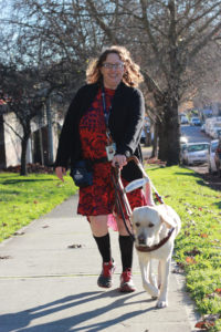 A photo of Melinda walking her guide dog, Leonardo