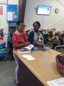 Two women posing at a counter smiling who were