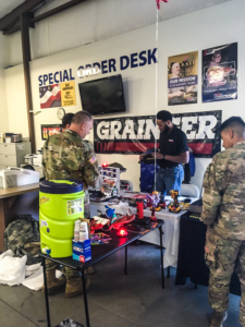 Three people browsing displays two in millitary uniform