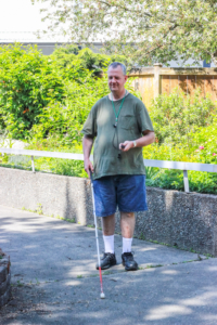 Paul Ducharme uses his white cane and a miniguide device to navigate safely around the Seattle campus