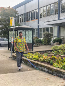 Meka White uses her white cane to navigate outside of the Seattle facility
