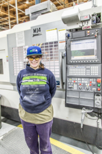 Rachel Talley standing in front of her CNC Machine