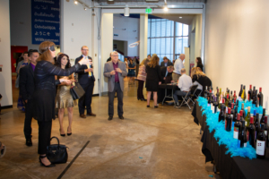 people playing ring toss onto wine bottles