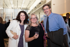 two women and a man smiling