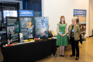 Two people posing in front a display table