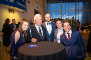 five people pose at a table