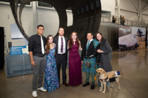 six people and a guide dog pose for photo