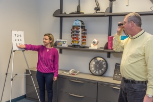 Dr. Anna Shagas (left) performs an eye exam with Michael Martens (right)