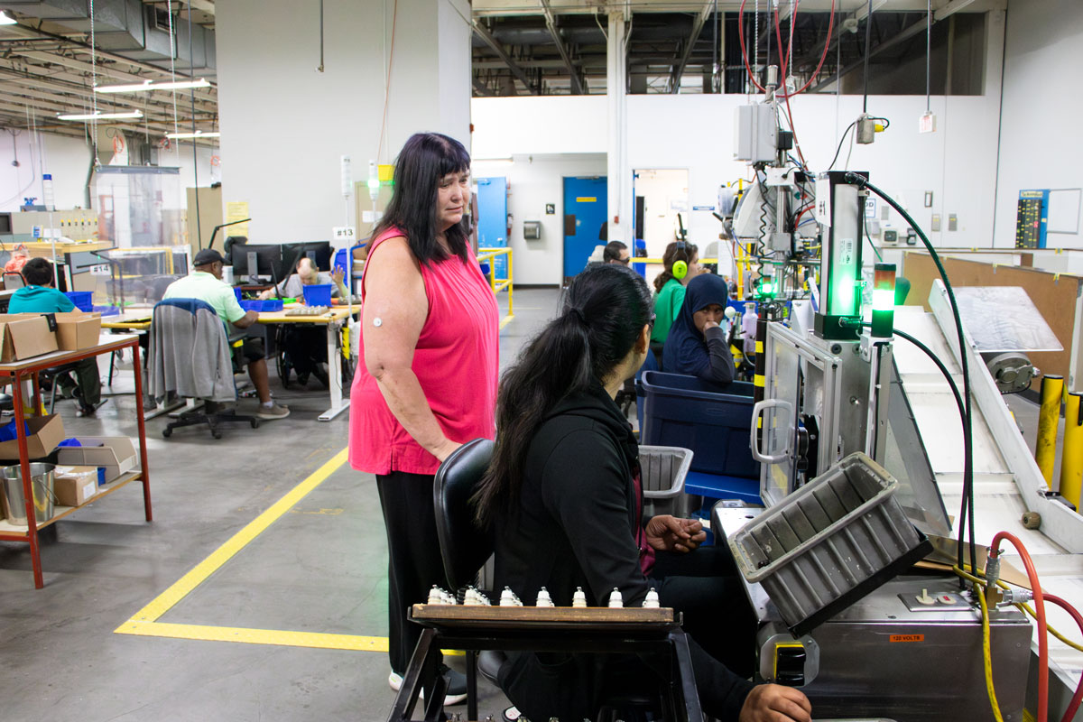 Carla working the production floor and speaking with her crew