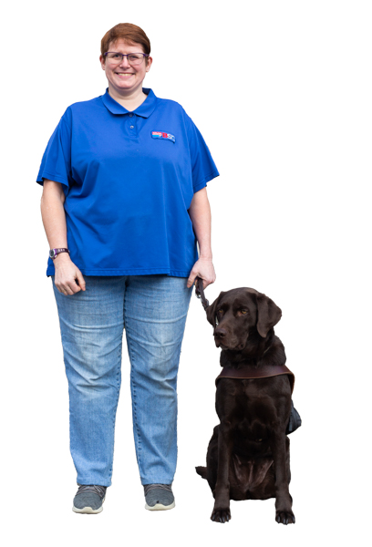 Colleen Smith, BSC Supply Clerk, a light skinned woman with red hair, stands with her dog guide beside her.