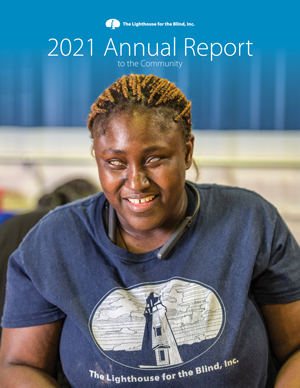 A close up photo of a dark skinned woman smiling. She is wearing a shirt with the Lighthouse logo on it. Text- 2021 Annual Report to the Community