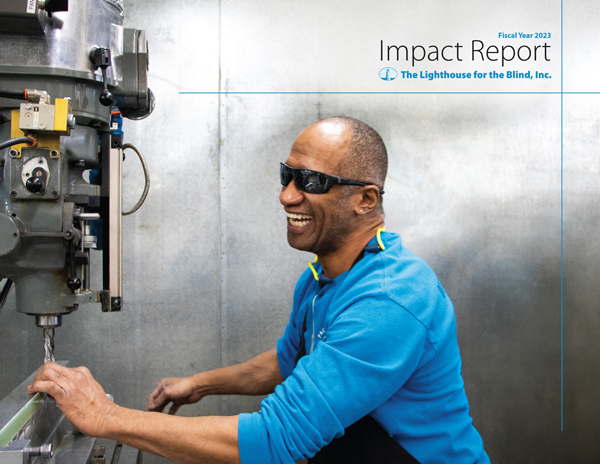 FY2023 Annual Report cover image featuring Jacob Kamaunu, a man with medium dark skin is standing in front of a large machine, wearing dark sunglasses and laughing.