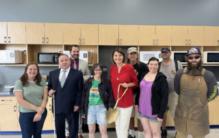 Representative McMorris Rodgers stands with 8 Lighthouse employees and holds a golden shovel.