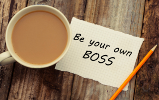 Image of a cup of coffee on a table, with a piece of paper that states "Be your own boss."