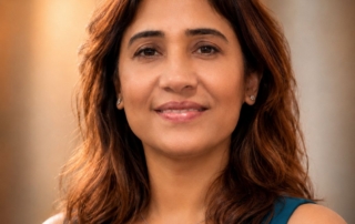 Portrait of a woman wearing a sleeveless shirt, with shoulder length brown hair