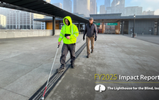A DeafBlind man wearing a high-vis jacket uses a miniguide and a white cane in Downtown Seattle while an Orientation and Mobility Instructor follows behind
