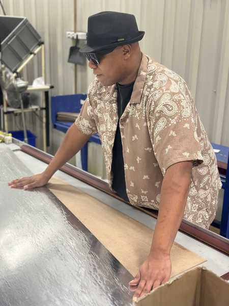 IMG_1995 Clevon Biggs – Spokane Manufacturing- Career Dev Program A man wearing a fedora is assembling wallboards in Spokane