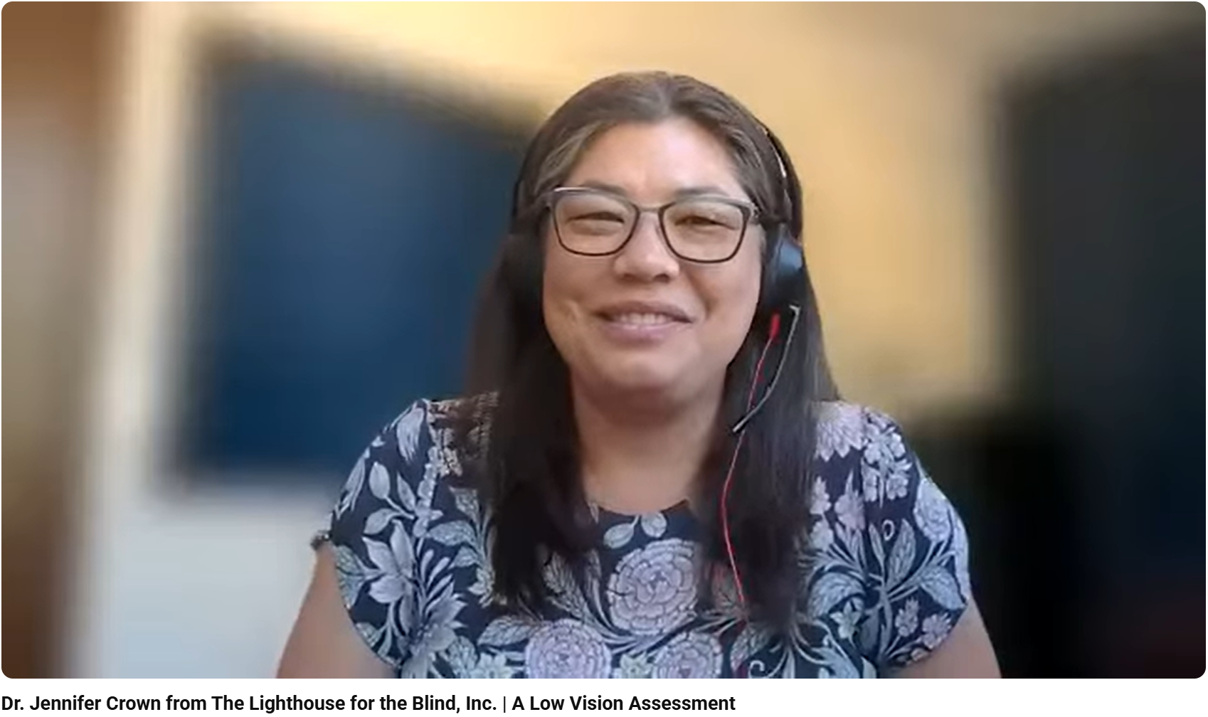 Video Screen Shot Dr. Jennifer Crown Smiling at the camera with a headset on, and a floral shirt.